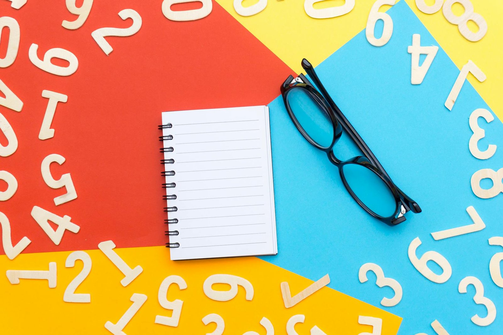 black framed eyeglasses beside notebook